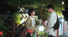 a man and a woman are standing next to each other in front of a building .
