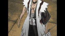 a man in a kimono is holding a sword and has blood on his chest .