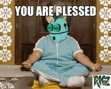 a cartoon character is sitting in a lotus position with the words you are blessed