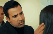 a man with a beard is looking at a woman
