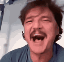 a man with a mustache is making a funny face with his mouth wide open .