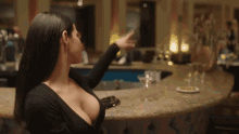 a woman sitting at a bar with a plunging neckline