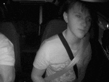 a young boy wearing a shirt that says ' i love you ' on it sits in the back seat of a car