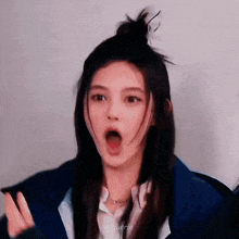a woman is making a funny face with her mouth open and a bun in her hair .