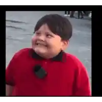 a young boy wearing a red shirt and a black tie is smiling .