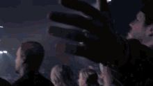 a group of people are standing in front of a crowd with their hands in the air