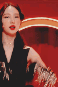 a woman in a black dress with silver fringe on her sleeves