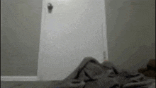a blurred image of a bedroom with a door and a blanket on the floor