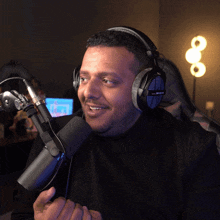 a man wearing a pair of beyerdynamic headphones is talking into a microphone