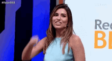 a woman in a blue top is standing in front of a sign that says rede bb