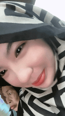 a close up of a woman 's face with a striped scarf around her head