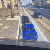 a blue car is parked on the side of a road in a video game