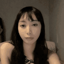 a close up of a woman 's face with long black hair