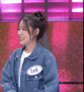 a woman wearing a blue denim jacket has a name tag on her chest that says ' ioi '