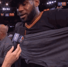 a man is being interviewed by a person with a nba logo on the microphone