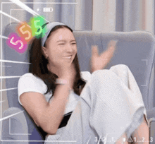 a woman is sitting in a chair with the number 55 on her headband