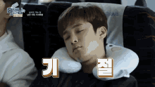 a young man sleeping on a plane with a pillow that says ' o'nl ' on it