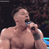 a man without a shirt is singing into a microphone with the name thekamdreesen on the bottom right
