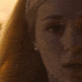 a woman wearing a headband and a pearl necklace looks at the camera