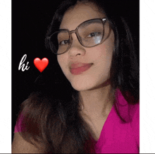 a woman wearing glasses and a pink shirt has a red heart and the word hi above her