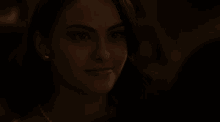 a close up of a woman 's face in a dark room