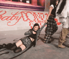 a woman is laying on the floor in front of a wall that says baby
