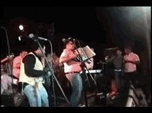a man in a cowboy hat is singing into a microphone while playing an accordion
