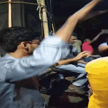 a man in a blue shirt is dancing in a crowd of people
