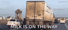 a truck is driving down a highway with the words milk is on the way written on the bottom