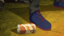 a person 's foot is standing next to a can that says coca cola on it