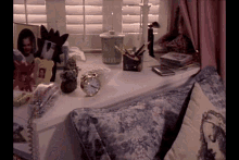 a clock sits on a table next to a pillow and a picture frame