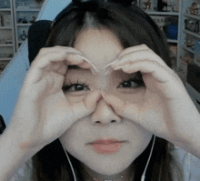 a woman making a heart shape with her hands