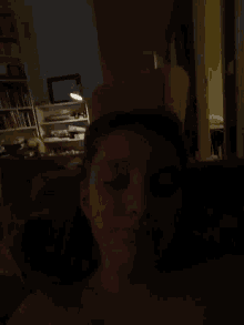 a person in a dark room with a picture on the wall that says ' jesus '