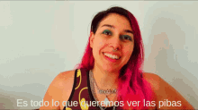 a woman with pink hair is smiling and the words es todo lo que queremos ver las pibas are behind her