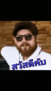 a man with a beard wearing sunglasses and a hat with a foreign language on it