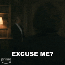 a woman is standing in a room with a man in the background and says `` excuse me ? ''