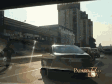 a car with a license plate that says paparazzi on it is driving down a street
