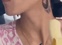 a close up of a woman 's neck and neckline with a tattoo on her neck .