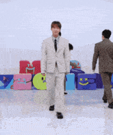 a group of young men in suits are dancing together