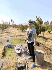 a young man in a t-shirt with a lion on it is standing in a field