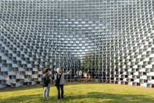 two people are standing in front of a building with a lot of squares
