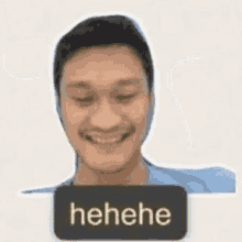 a man is smiling with a sticker that says ' hehe ' on his face .