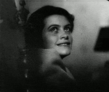 a black and white photo of a smiling woman