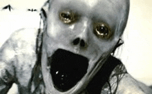 a black and white photo of a scary zombie with a skull on his face .
