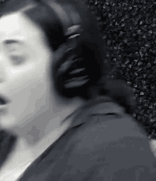a woman is wearing headphones and singing in a black and white photo .