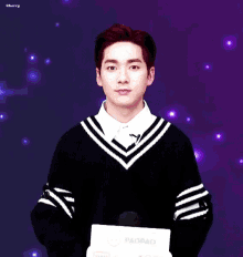a young man in a black and white striped sweater holds a sign that says paopao