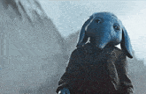 a blue elephant is wearing a sweater and a jacket .