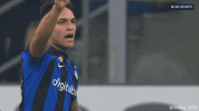 a soccer player wearing a blue and black jersey with digitalbit on it