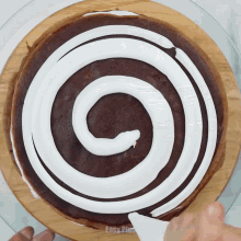 a cake with a swirl of white frosting on it is being decorated by easy peasy