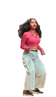 a woman in a pink crop top and blue pants is jumping in the air